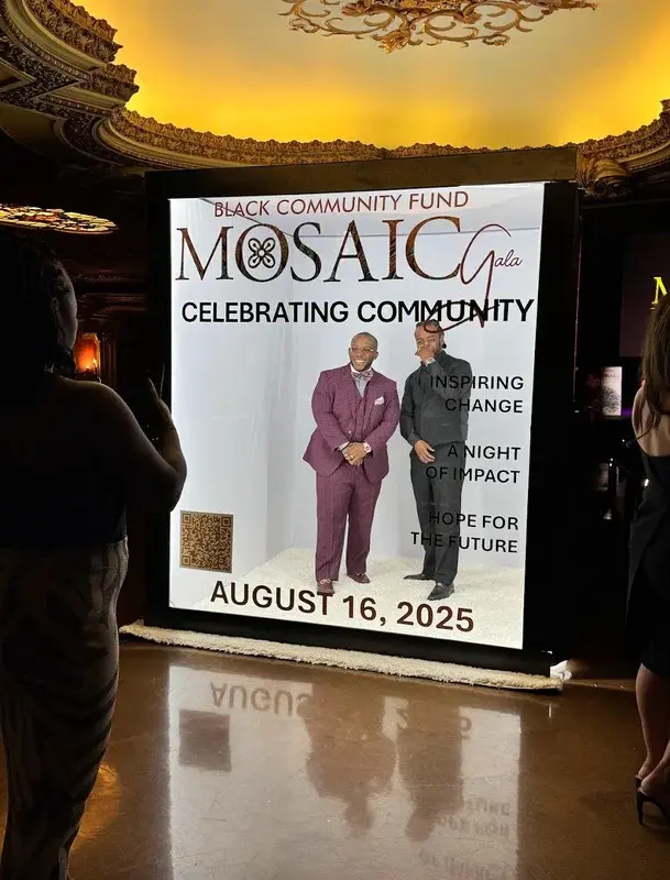 Guests posing inside a walk-in magazine booth at a Kansas City gala