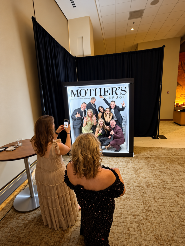 Guests photographing their custom magazine cover in a walk-in magazine booth